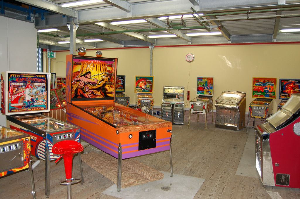 Raum mit mehreren Flipperautomaten und Jukeboxen.