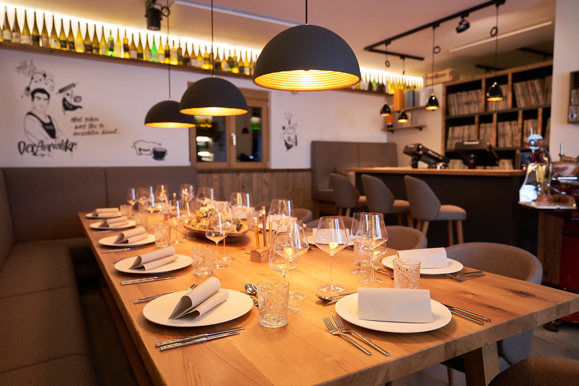 Eleganter, gedeckter Tisch in einem stilvollen Restaurant mit warmem Licht und moderner Dekoration.