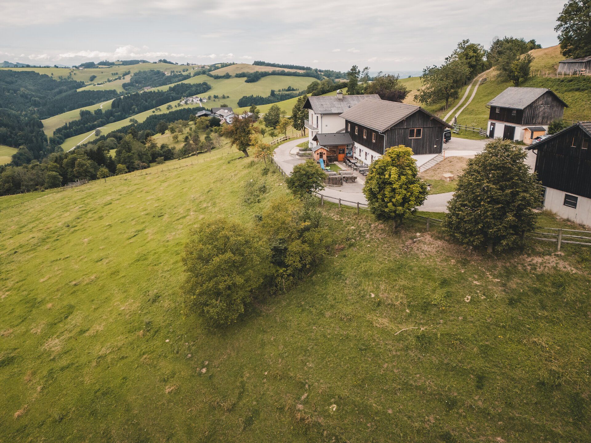 Eine Luftaufnahme, die die Lage des Almhauses Hochkogel in der offenen Hügellandschaft betont – weite Blicke über das Mostviertel und der Moststraße.