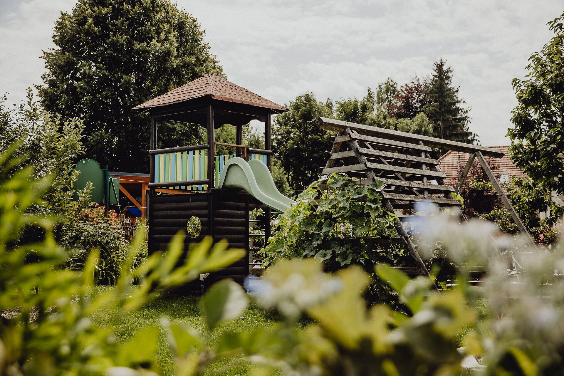Ein einladender Spielplatz umgeben von üppigem Grün bietet Kindern die Möglichkeit, unbeschwerte Stunden im Freien zu verbringen. Die sanften Hügel und die frische Luft des Wienerwaldes schaffen eine harmonische Atmosphäre, die zum Verweilen einlädt.