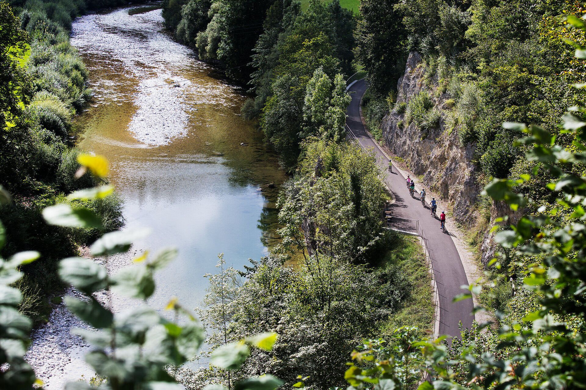 Entlang des Ybbstalradwegs schlängelt sich der ruhige Fluss Kogelsbach durch eine malerische Landschaft, umgeben von üppigem Grün und sanften Hügeln. Radfahrer genießen die frische Luft und die atemberaubenden Ausblicke, während die Natur in voller Blüte steht.
