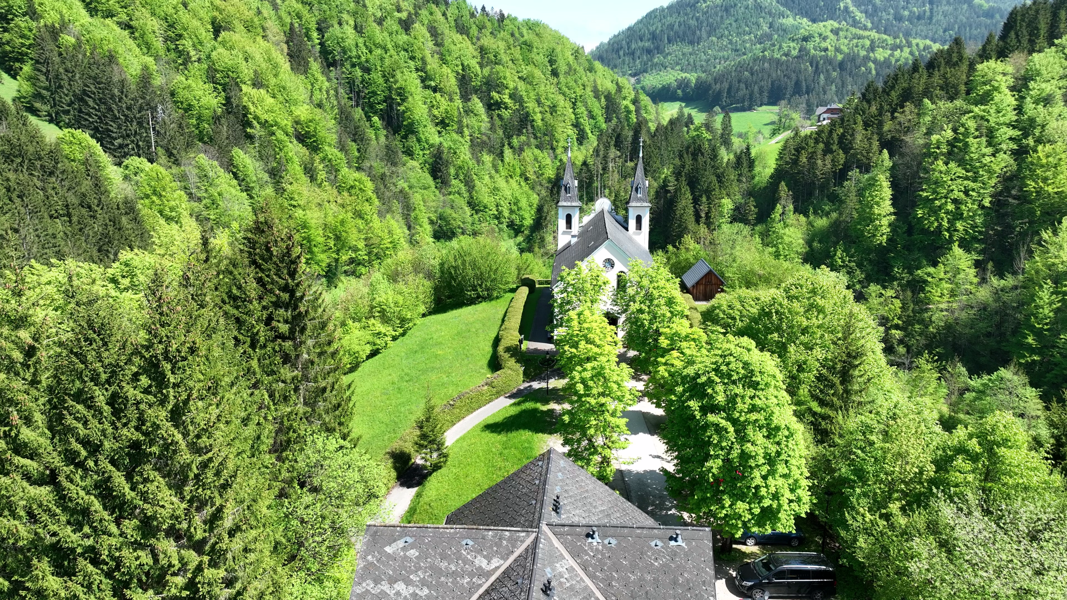 Luftaufnahme der Wallfahrtskirche Maria Seesal, umgeben von grünen Wäldern und Hügeln.