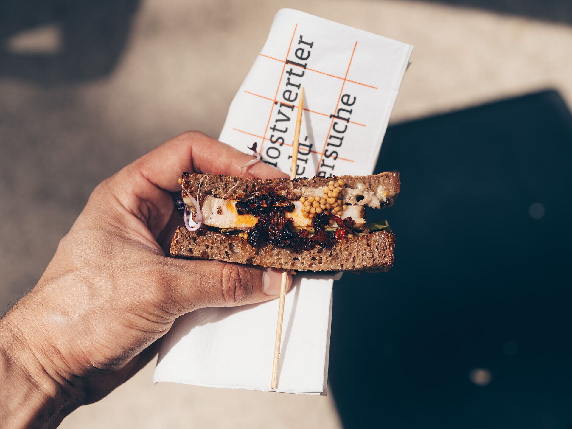 Ein köstlicher Bissen aus frisch zubereitetem Street Food vereint die Aromen der Region und lädt zum Genießen ein. Die lebendige Atmosphäre des Events zieht Gourmets und Neugierige gleichermaßen an, während die Sonne über dem Schloss Rothschild strahlt.