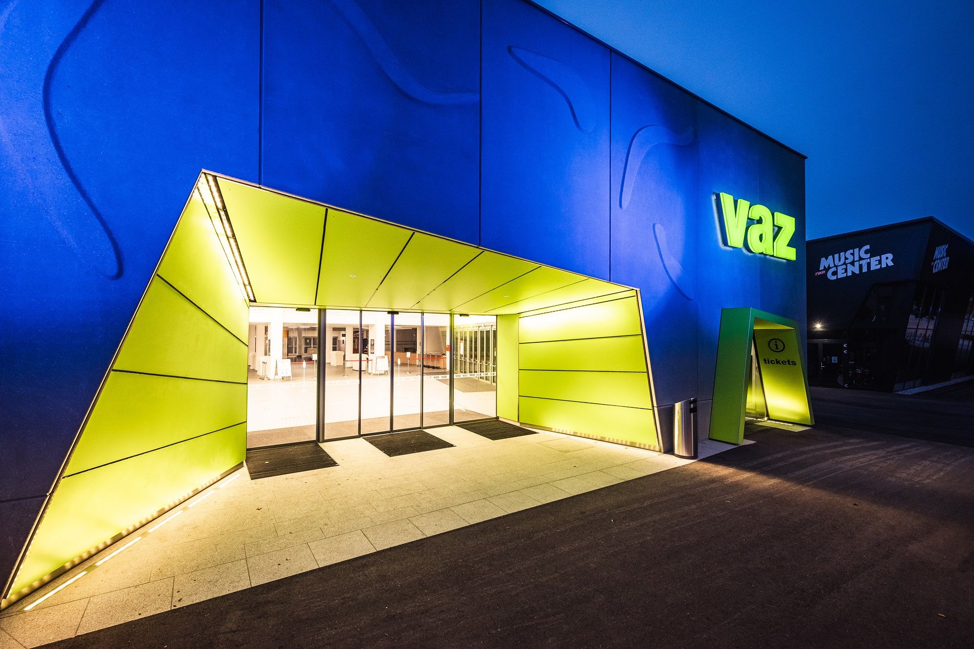 Eingang des VAZ St. Pölten mit beleuchtetem Schild und moderner Architektur.