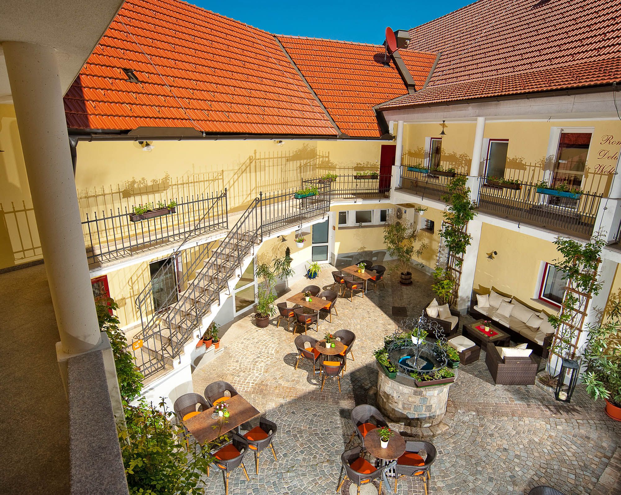 Innenhof der Residenz Wachau mit Tischen, Stühlen und einem Brunnen.