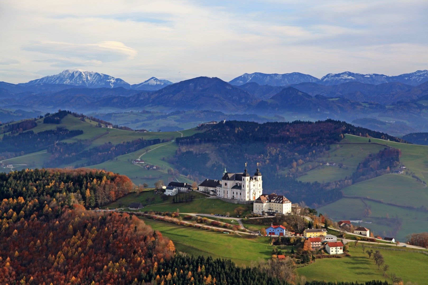 Panoramablick über das Mostviertel mit der Basilika Sonntagberg im Vordergrund und Bergen im Hintergrund.