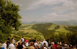 Gruppe von Menschen genießt Ausblick über die Hügellandschaft.