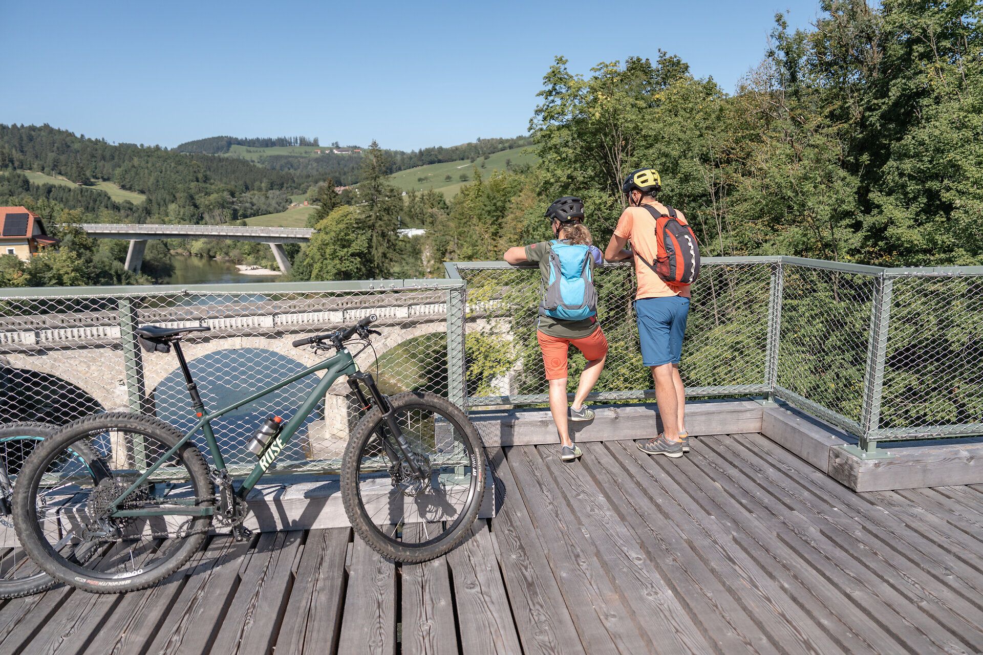 Die sanfte Brise trägt den Duft der umliegenden Wälder, während Radfahrer die atemberaubende Aussicht auf die Ybbstaler Alpen genießen. Die Sonne strahlt am klaren Himmel und lädt dazu ein, die Natur in vollen Zügen zu erleben. Hier, an einem malerischen Aussichtspunkt, verschmelzen Abenteuer und Entspannung zu einem unvergesslichen Erlebnis.