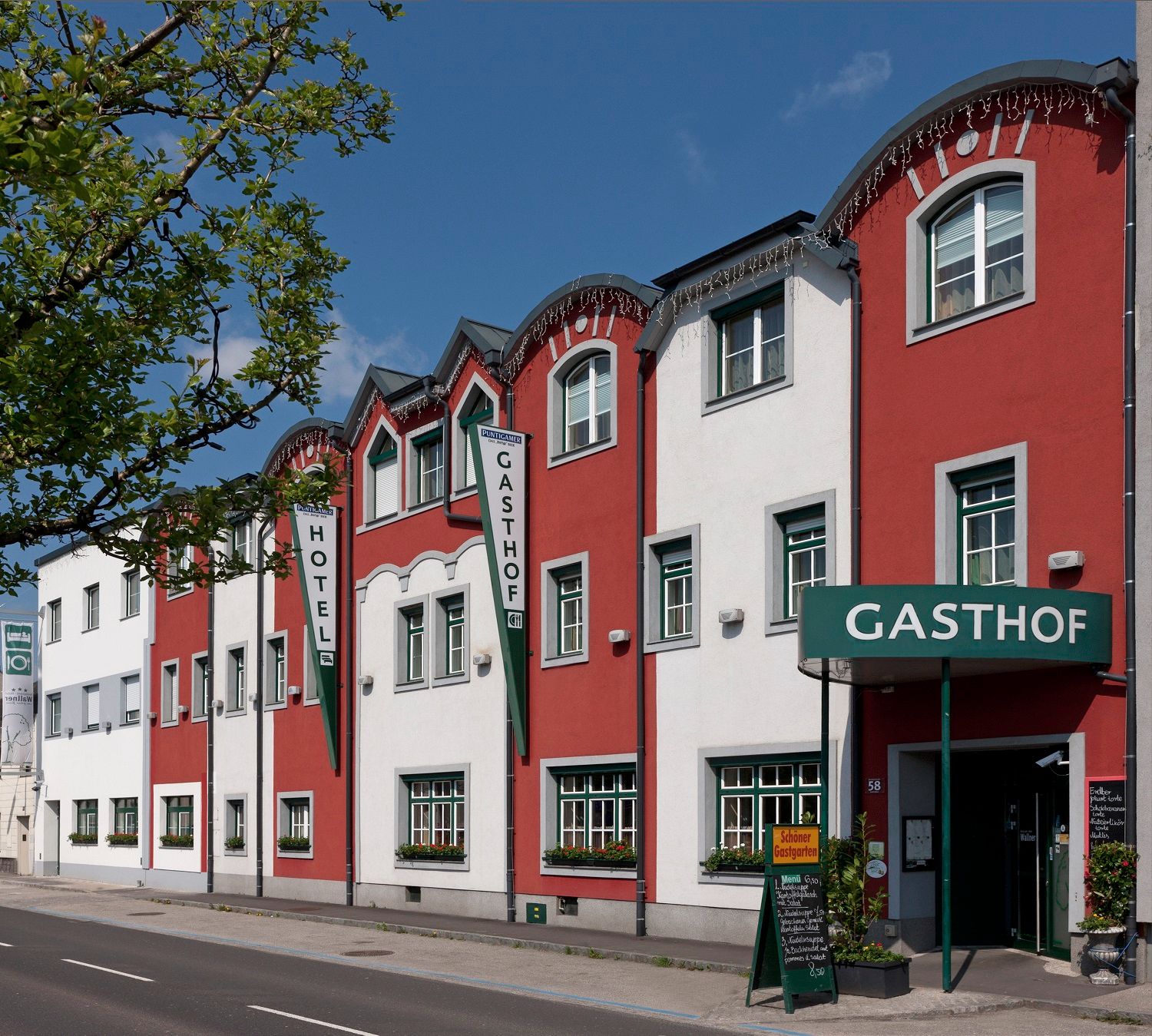 Außenansicht des Restaurant-Hotels Wallner mit roter und weißer Fassade.