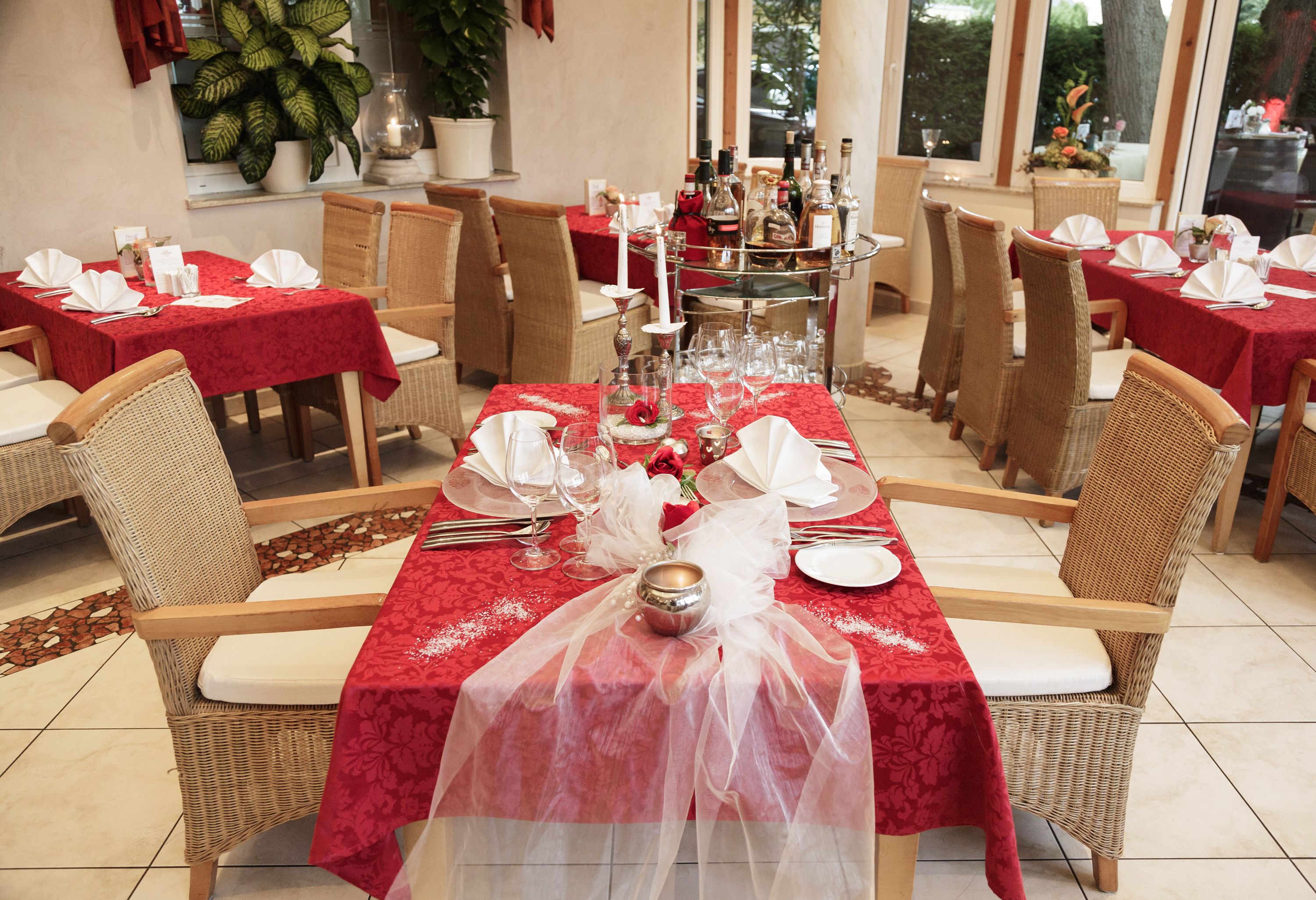 Elegantes Restaurant mit roten Tischdecken und gedeckten Tischen.