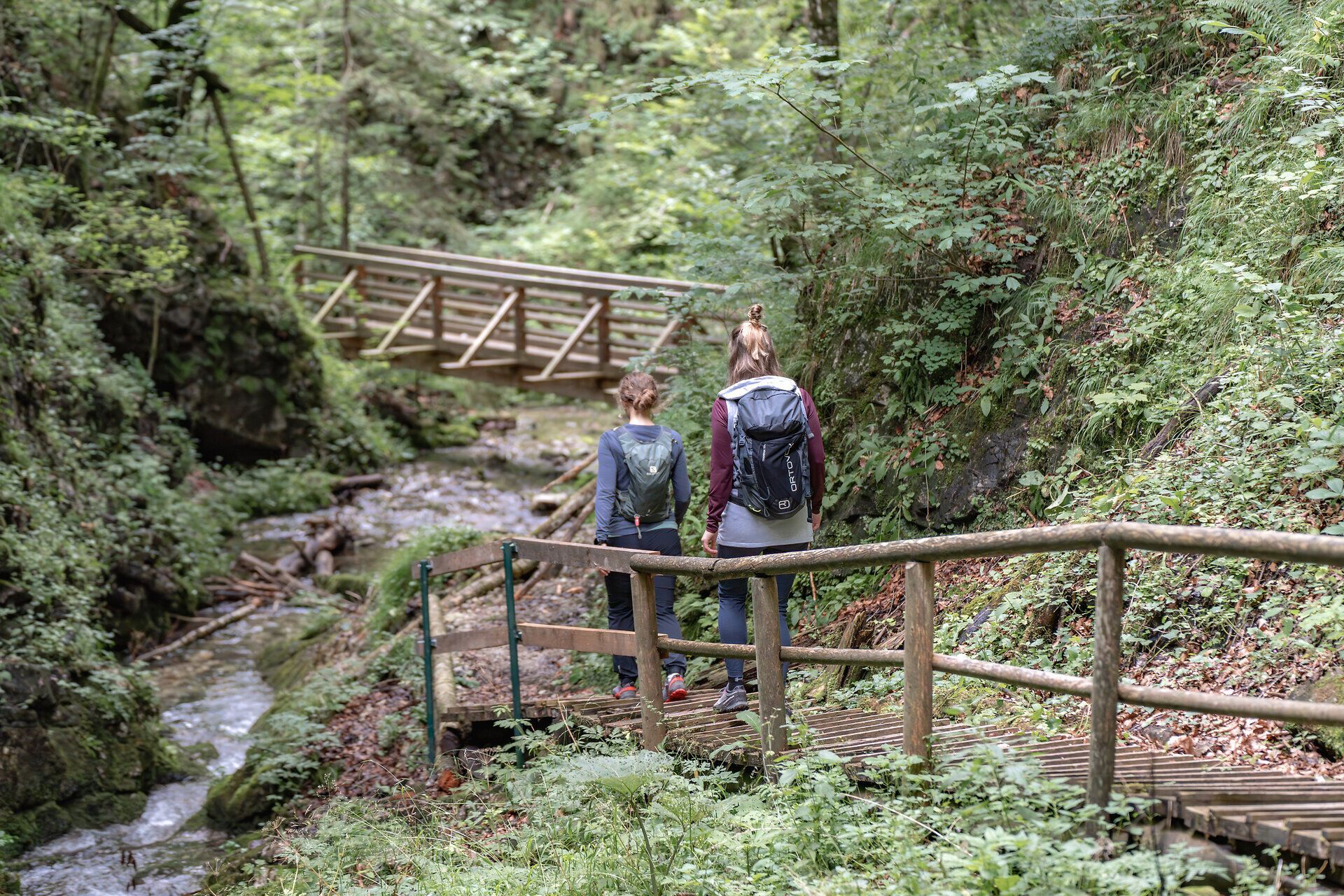 Ein malerischer Wanderweg schlängelt sich entlang des glitzernden Wassers, umgeben von üppigem Grün und dem sanften Rauschen der Kogler Wasserfälle. Die frische Bergluft und das Plätschern des Wassers schaffen eine entspannende Atmosphäre, die zum Verweilen einlädt.