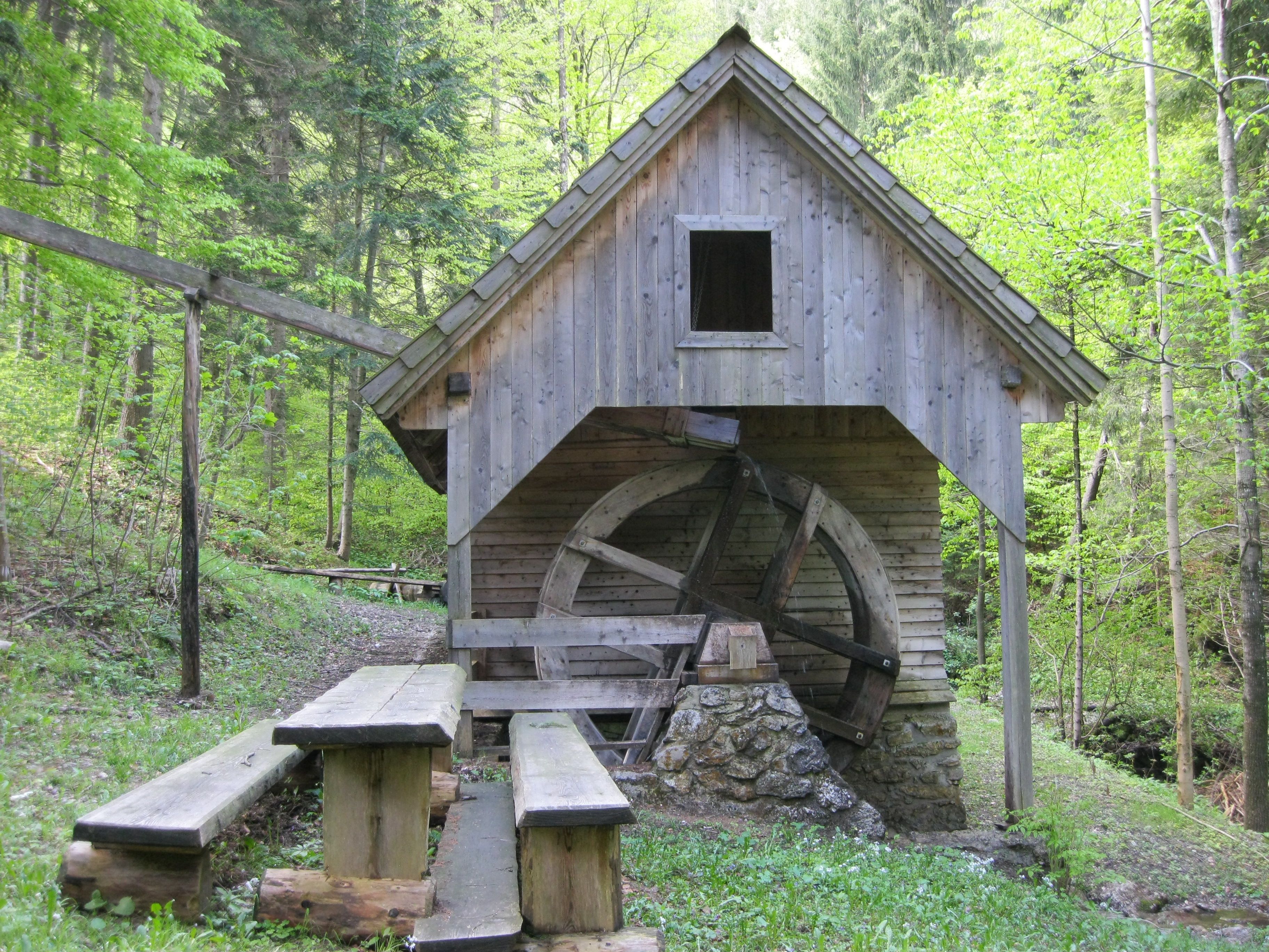 Holzmühle mit Wasserrad im Wald