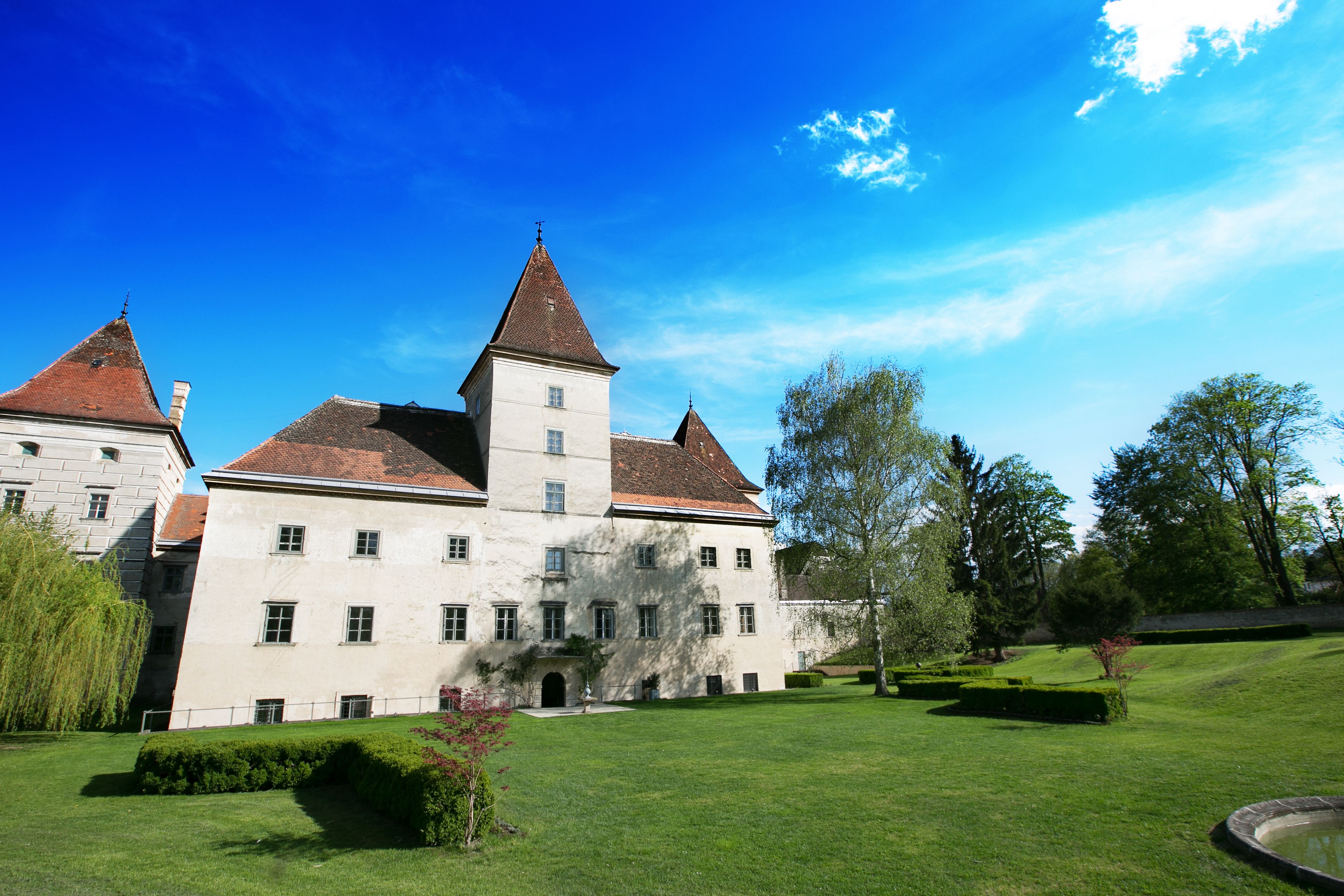 Schloss Walpersdorf mit Garten und blauem Himmel.