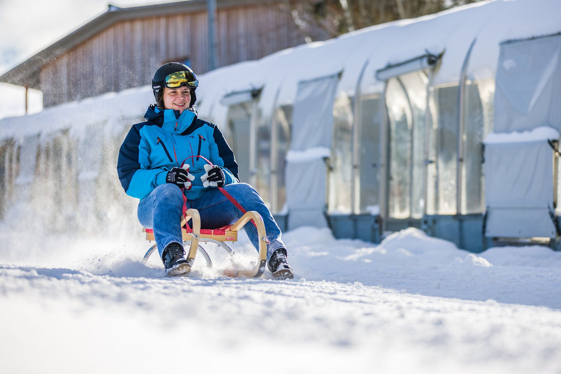 Ein fröhlicher Rodler saust mit einem breiten Lächeln den verschneiten Hang hinunter. Die glitzernde Schneedecke und die klare Winterluft schaffen eine perfekte Kulisse für unvergessliche Abenteuer im Winter. Hier in den Annaberger Liften wird jeder Tag zum Erlebnis.