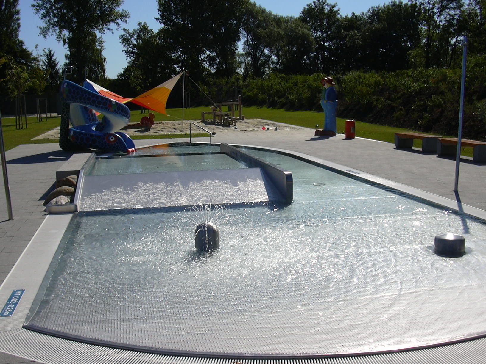 Kinderbecken mit Rutsche und Wasserspiel im Freien.