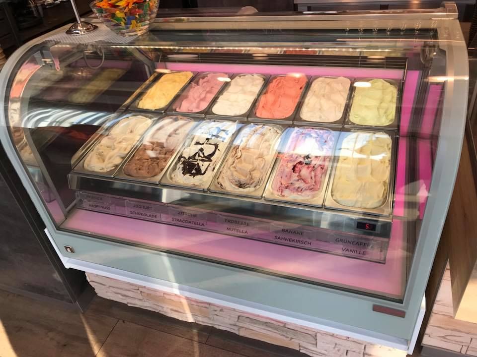 Eisvitrine mit verschiedenen Eissorten in einem Eissalon.