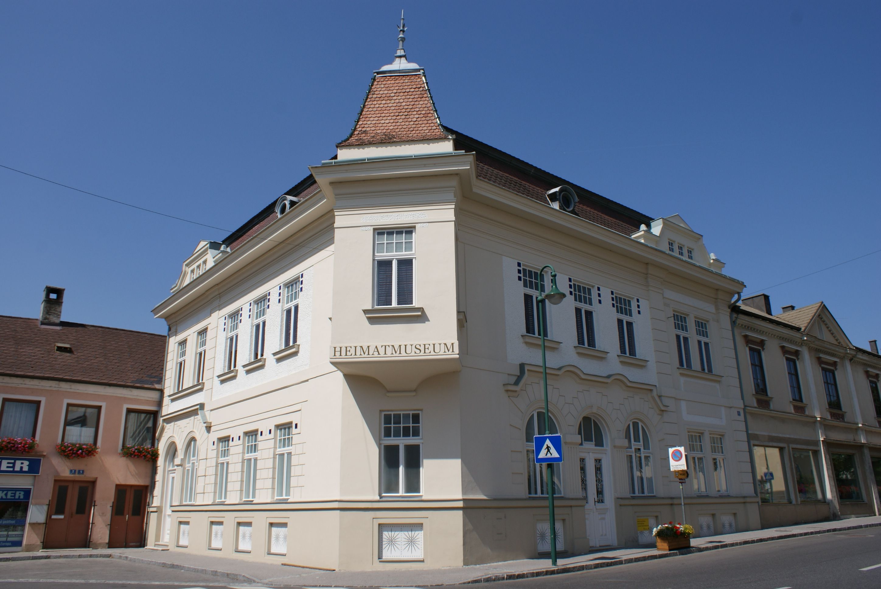 Ein historisches Gebäude mit der Aufschrift 'Heimatmuseum' in Mank, Österreich, bei klarem Himmel.