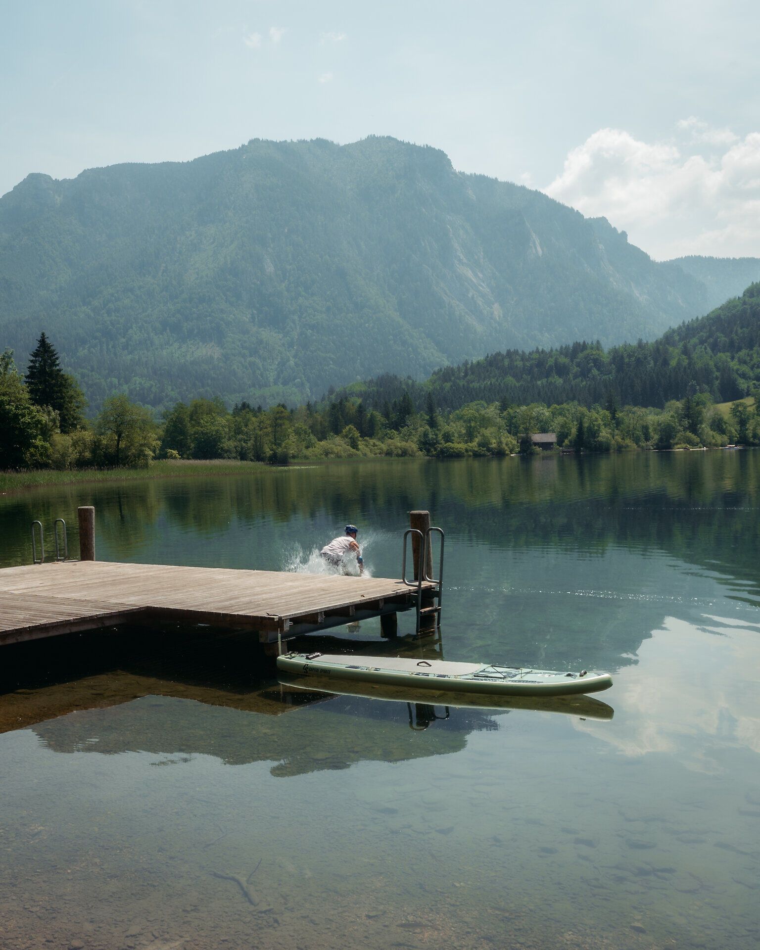 Ein erfrischendes Plätschern erfüllt die Luft, während ein mutiger Schwimmer ins glitzernde Wasser des Lunzer Sees eintaucht. Umgeben von majestätischen Bergen und üppigem Grün, lädt dieser Ort dazu ein, die Seele baumeln zu lassen und die Schönheit der Natur zu genießen.