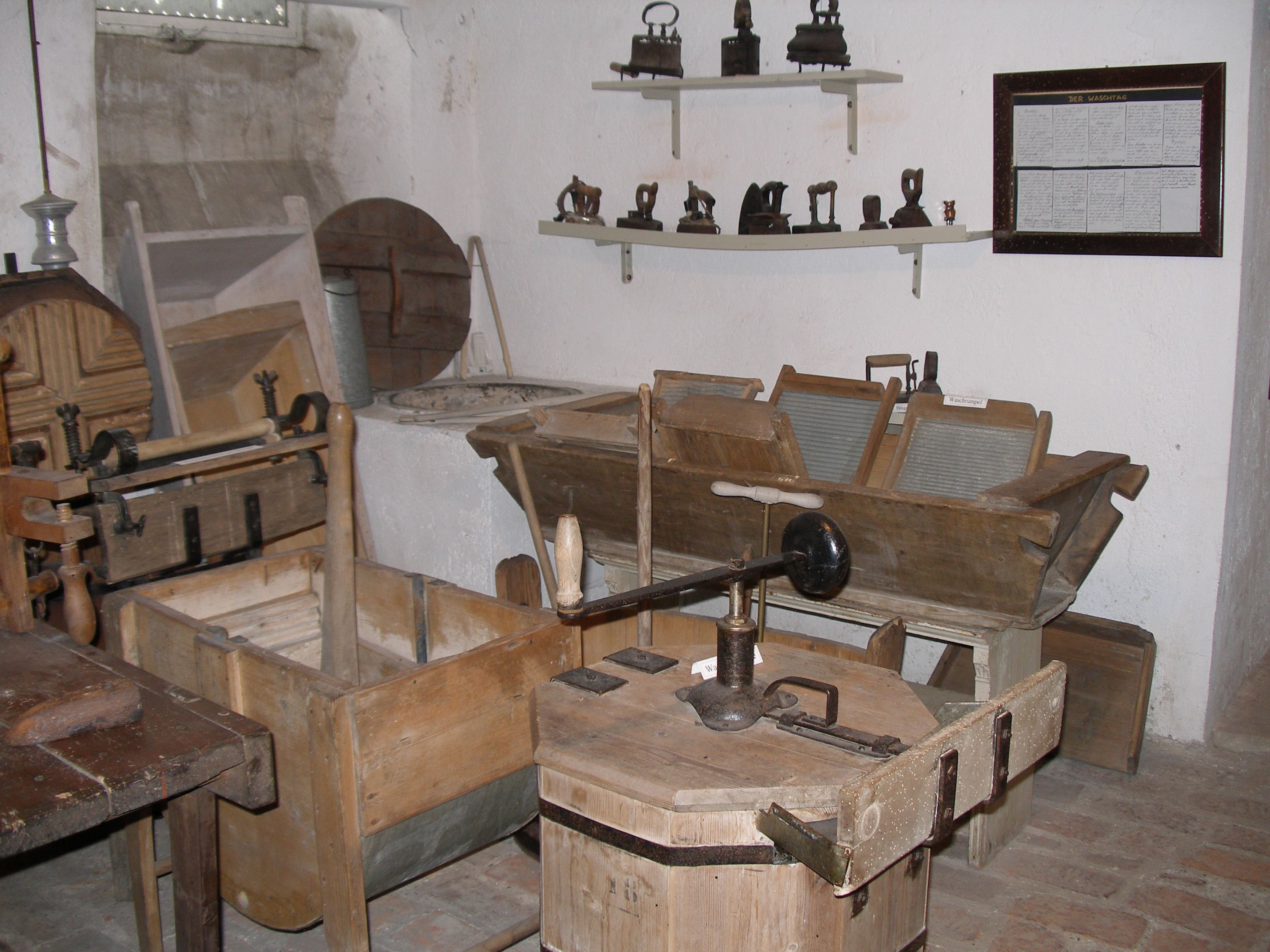 Ein Raum mit alten Haushaltsgeräten wie Waschbrettern und Bügeleisen.