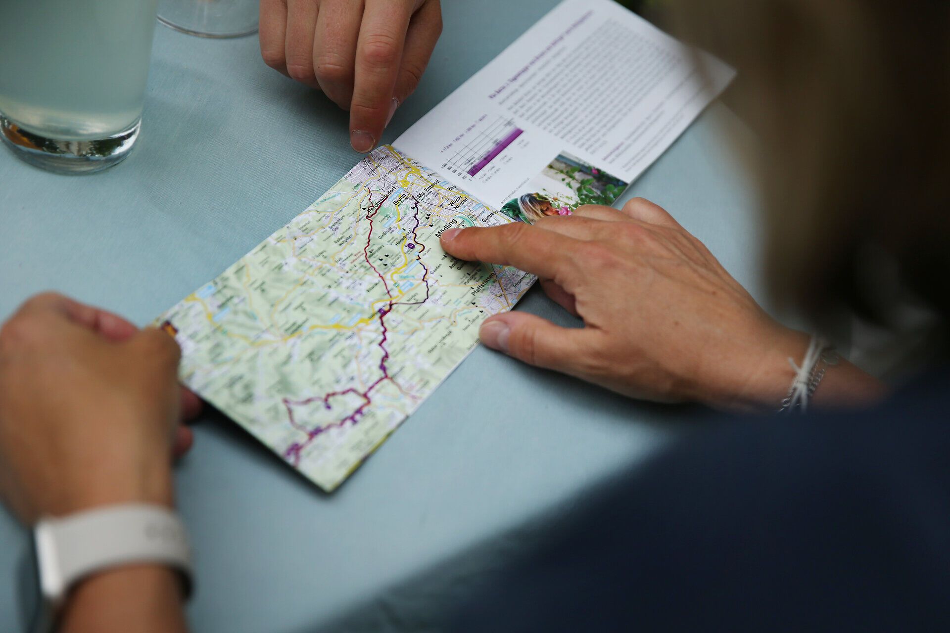 Zwei Wanderer studieren aufmerksam eine Karte, während sie sich auf ihre Pilgerwanderung vorbereiten. Umgeben von der malerischen Natur und der frischen Bergluft, spüren sie die Vorfreude auf die bevorstehenden Abenteuer entlang der Via Sacra. Die sanften Hügel und die üppige Vegetation laden dazu ein, die Seele baumeln zu lassen und die Schönheit der Umgebung zu genießen.