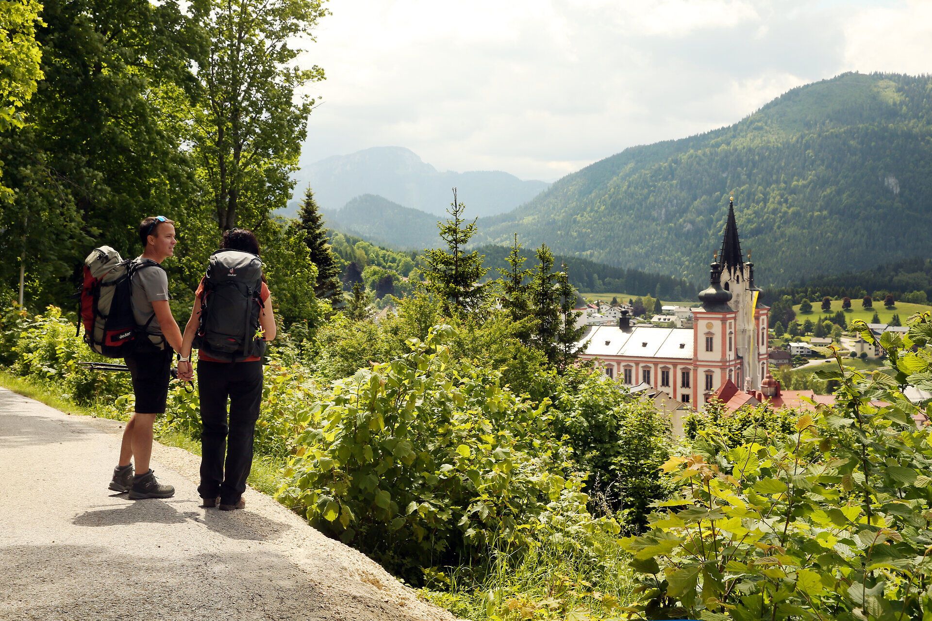 Umgeben von majestätischen Bergen und üppigem Grün, genießen Wanderer die frische Bergluft und die atemberaubende Aussicht auf die idyllische Landschaft. Die charmante Basilika, ein beliebtes Ziel für Pilger, strahlt Ruhe und Spiritualität aus und lädt dazu ein, innezuhalten und die Schönheit der Natur zu erleben.
