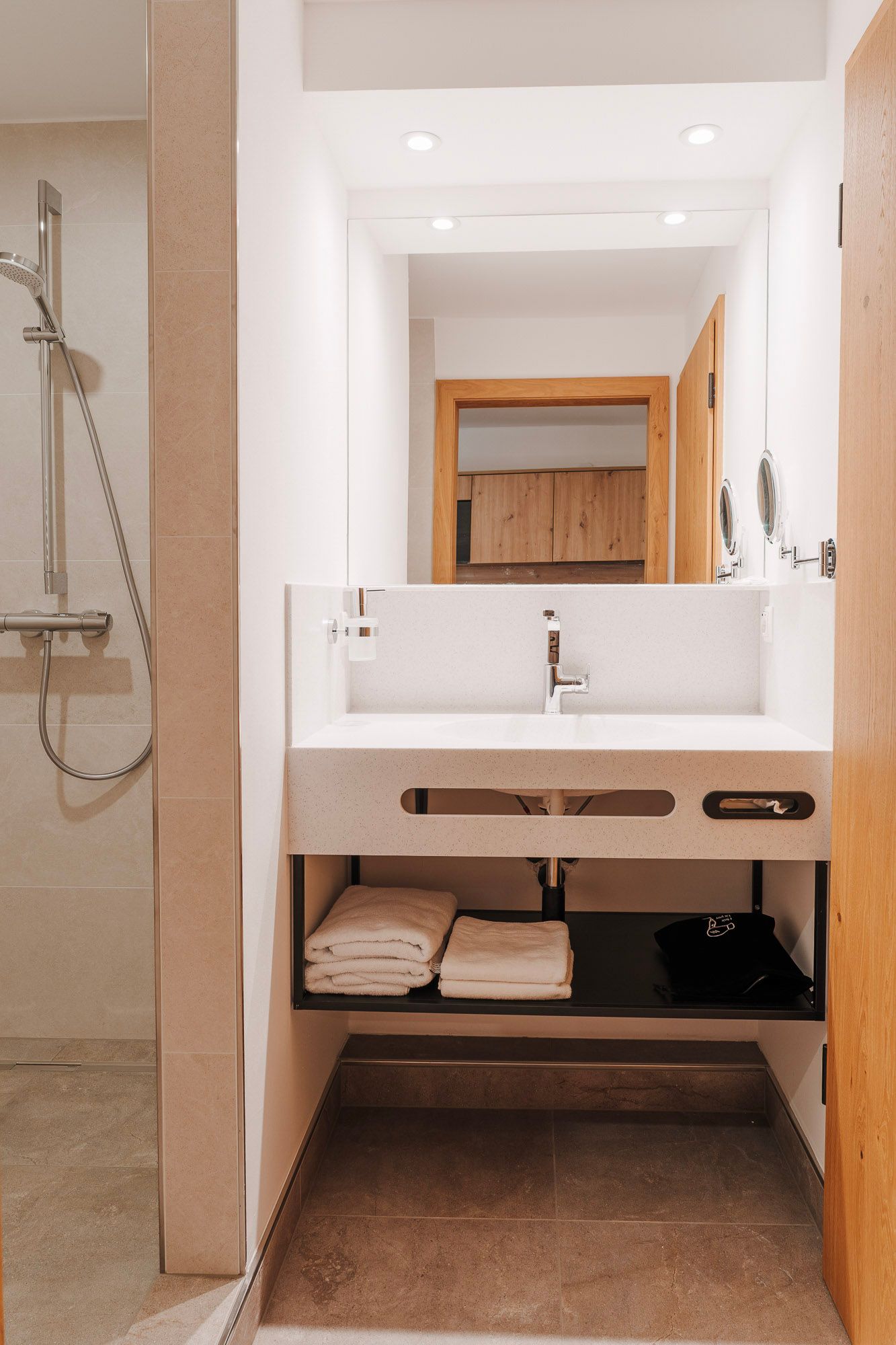 Modernes Badezimmer mit Waschbecken, Spiegel und Dusche.