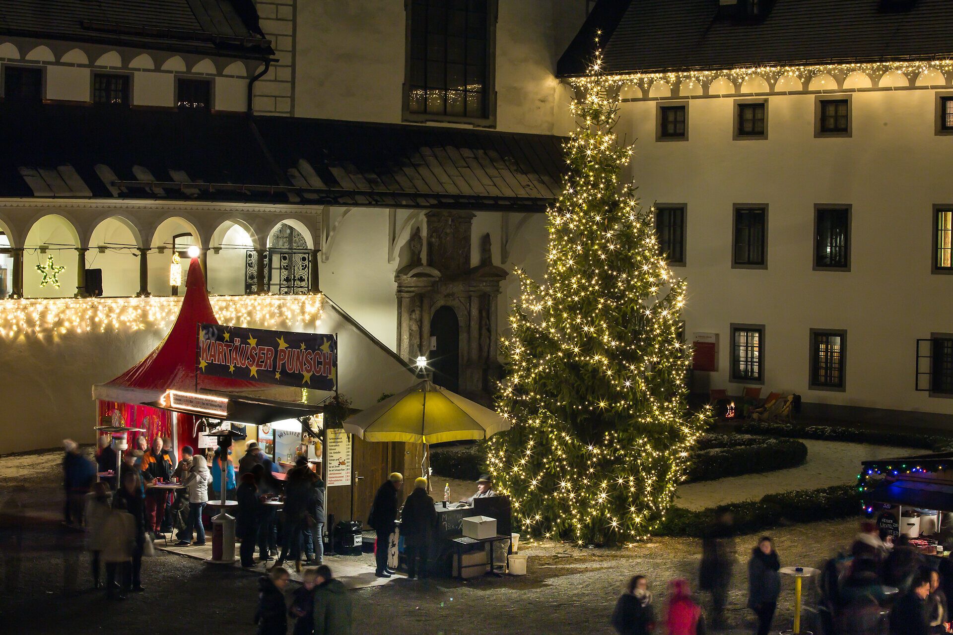 Der festlich beleuchtete Weihnachtsmarkt verzaubert mit seinem warmen Licht und der einladenden Atmosphäre. Umgeben von historischen Gebäuden und einem prächtigen Weihnachtsbaum, genießen die Besucher die köstlichen Leckereien und die festliche Stimmung. Ein Ort, an dem die Vorfreude auf das Weihnachtsfest spürbar wird.