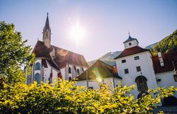 Kartause Gaming mit Klosterkirche und historischen Gebäuden vor der Bergkulisse.