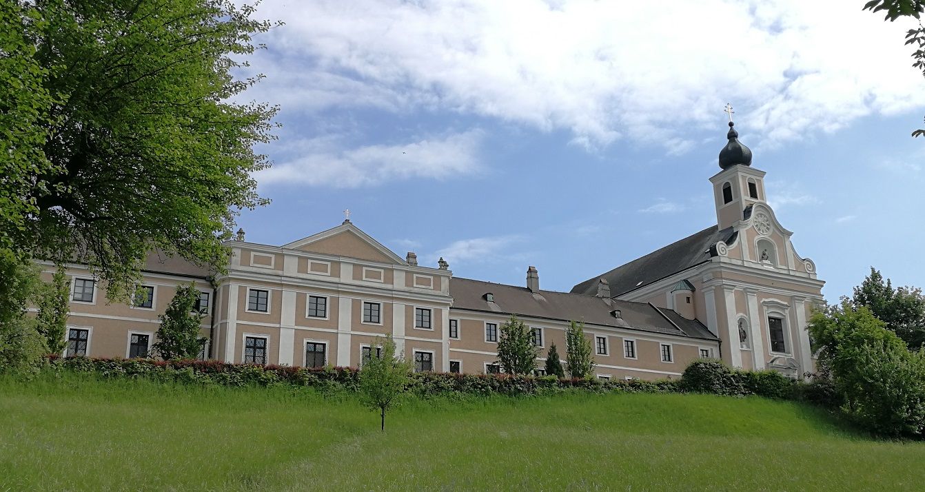 Wallfahrtskirche Maria Jeutendorf mit blauem Himmel und grüner Wiese.