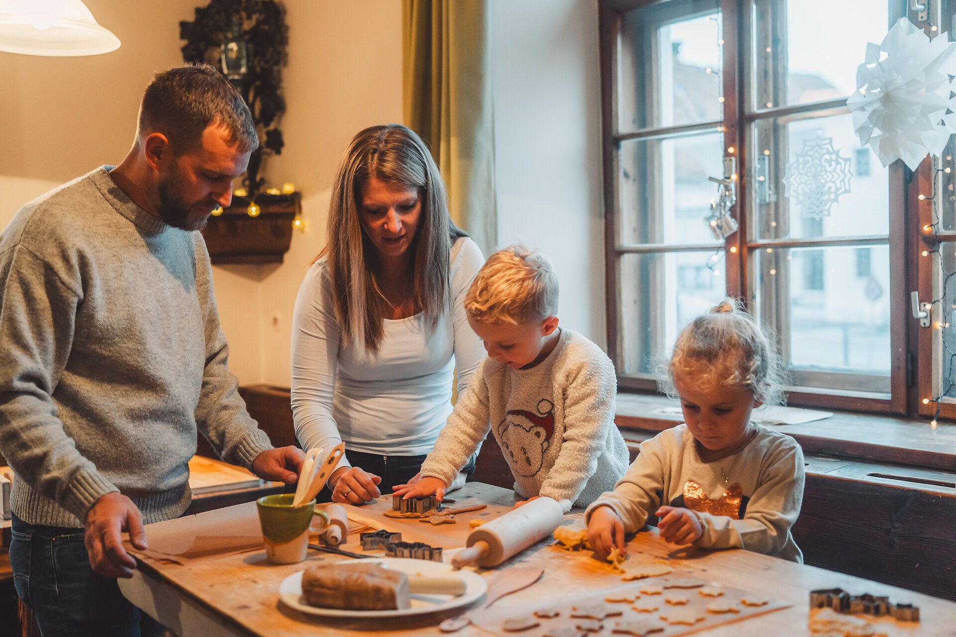 Familie backt gemeinsam Kekse auf dem Adventmarkt der Flammenden Weihnacht in Scheibbs. 