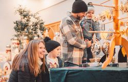 Familie bestaunt die handgefertigten Stücke auf dem Adventmarkt in Scheibbs.