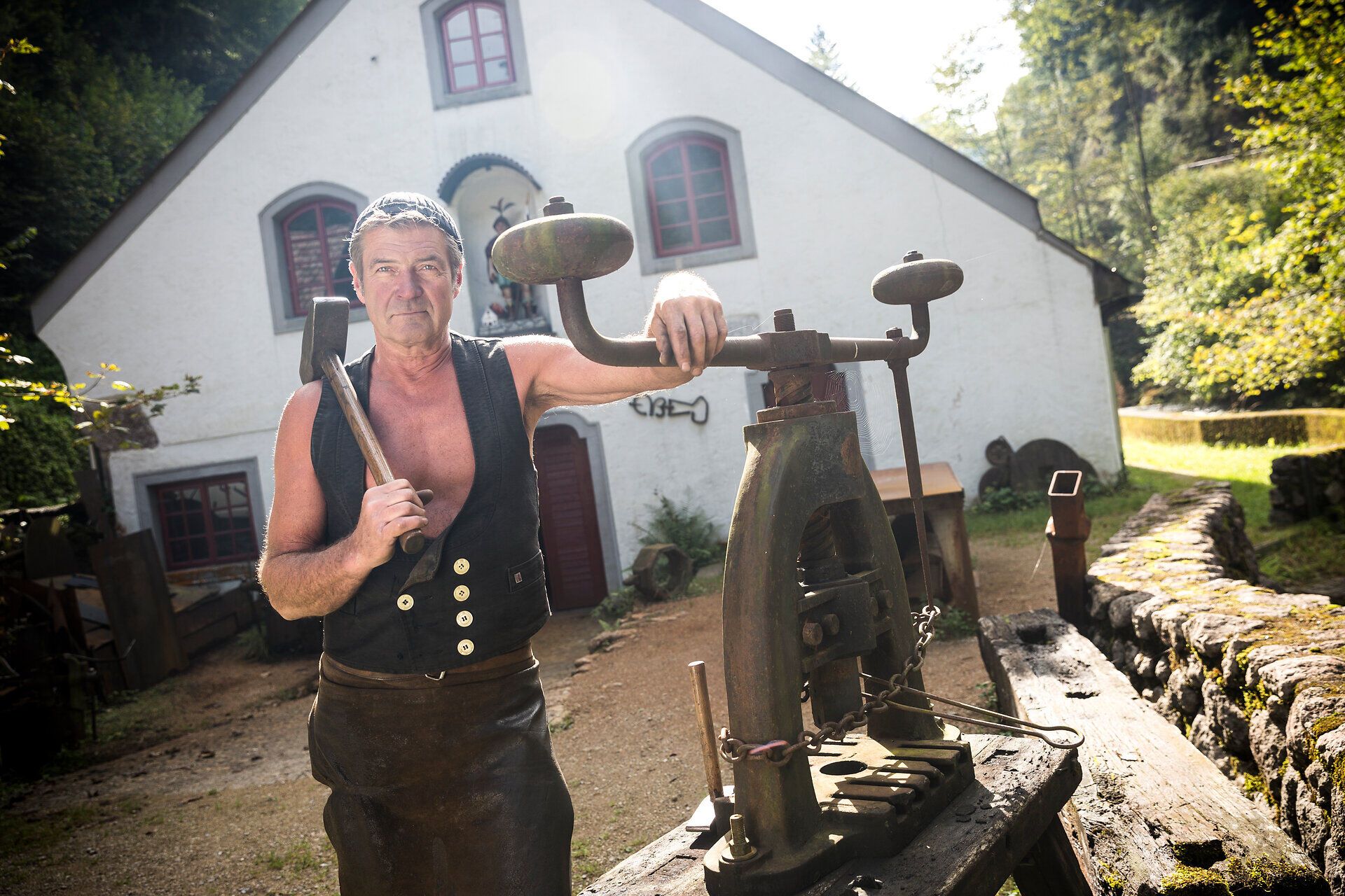 In der malerischen Kulisse der Ybbstaler Alpen steht ein erfahrener Schmied, der mit Leidenschaft und Geschick sein Handwerk ausübt. Die warmen Sonnenstrahlen tauchen die Szene in ein goldenes Licht und verleihen der Umgebung eine einladende Atmosphäre. Hier, wo Tradition und Kunstfertigkeit aufeinandertreffen, spürt man die Geschichte des Schmiedezentrums förmlich.