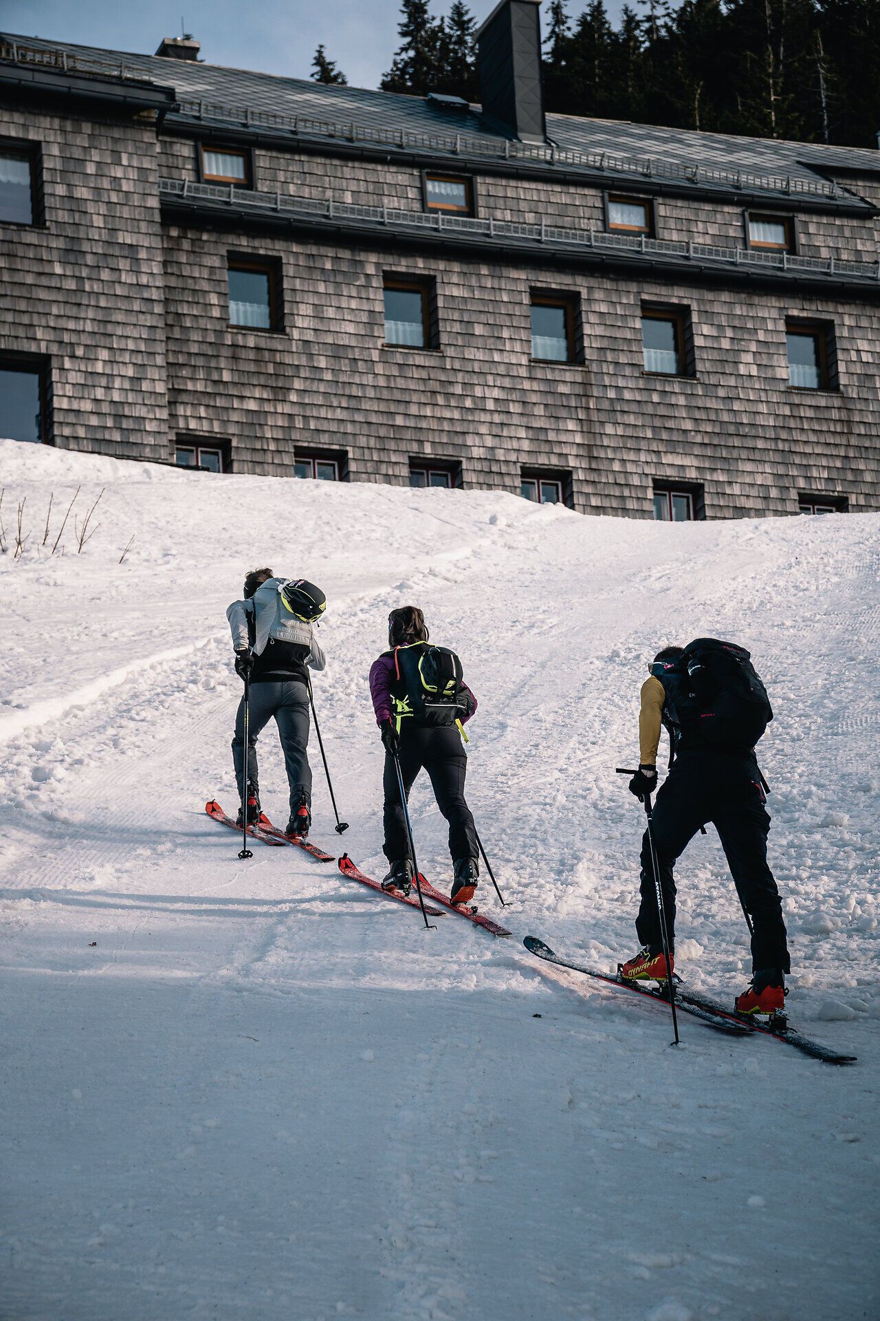 Die frische Winterluft umhüllt die Skitourengeher, während sie den schneebedeckten Hang hinaufsteigen. Umgeben von der majestätischen Kulisse der Ybbstaler Alpen, spüren sie die Ruhe und Schönheit der Natur. Das Ötscherschutzhaus bietet einen einladenden Halt für alle, die die winterliche Landschaft genießen möchten.