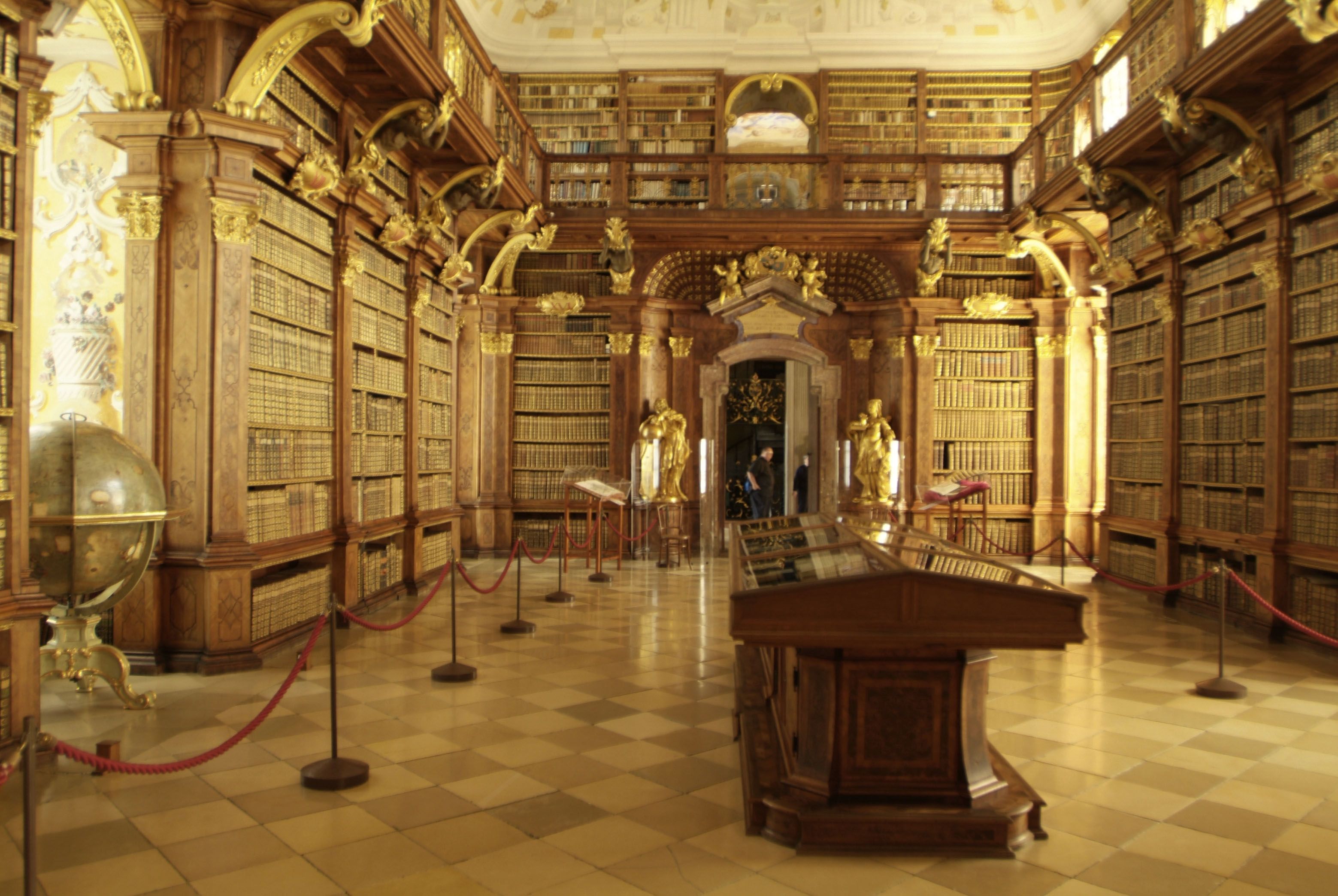 Innenansicht der Bibliothek im Stift Melk mit hohen Bücherregalen und dekorativen Elementen.