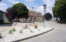 Gemeindeamt von Golling an der Erlauf mit Blumenbeet im Vordergrund.