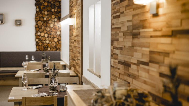 Gem&uuml;tliches Restaurant mit Holzw&auml;nden und dekorierten Tischen.