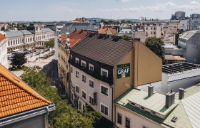 Luftaufnahme eines Hotel-Gasthofs in St. P&ouml;lten mit umliegenden Geb&auml;uden und Stra&szlig;en.