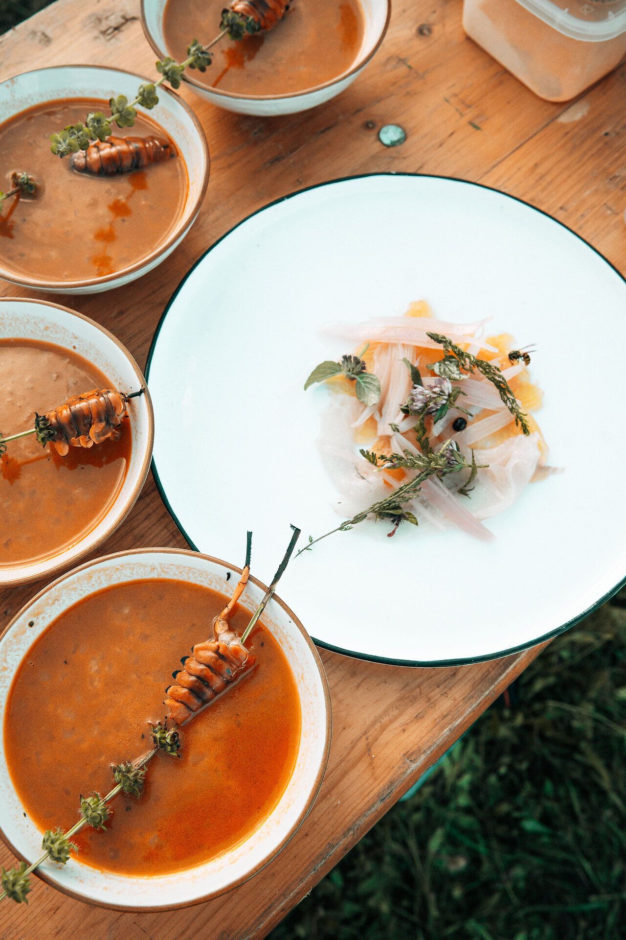 Inmitten eines malerischen Birnengartens laden köstliche Speisen und aromatische Getränke zum Verweilen ein. Die rustikale Atmosphäre und die frische Luft schaffen eine einladende Stimmung, die zum Genießen und Entspannen einlädt.