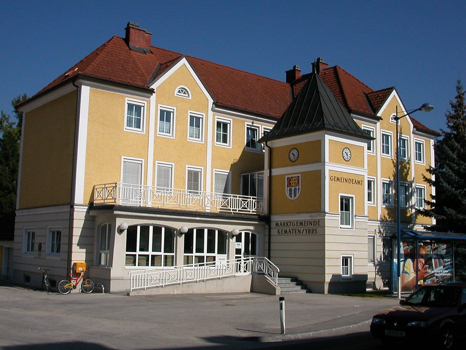 Gelbes Gebäude des Gemeindeamts Kematen an der Ybbs mit Uhr und Wappen.