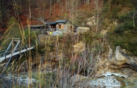 Holzh&uuml;tte in den &Ouml;tschergr&auml;ben mit Br&uuml;cke und herbstlicher Landschaft.