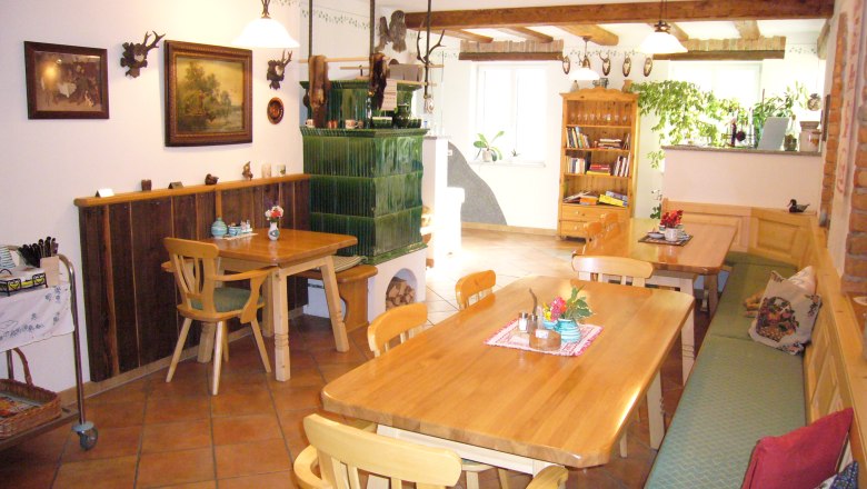 Gemütlicher Gastraum mit Holzmöbeln und Kachelofen.