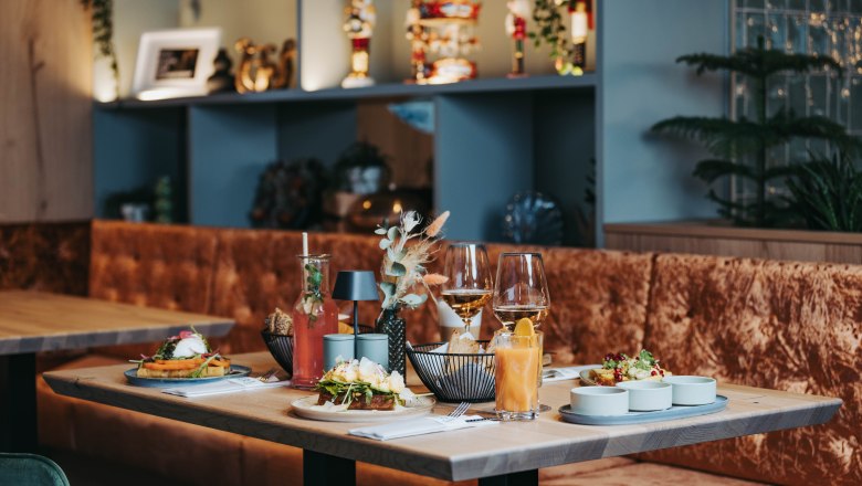 Gedeckter Tisch mit Speisen und Getr&auml;nken in einem stilvollen Restaurant.