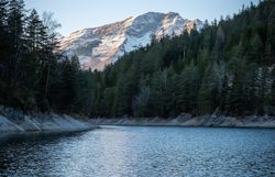 Die sanften Wellen des Erlaufstausees spiegeln die majestätischen Berge wider, während die winterliche Stille die Luft erfüllt. Umgeben von dichten Wäldern und schneebedeckten Gipfeln, lädt diese idyllische Landschaft zu einem unvergesslichen Naturerlebnis ein.