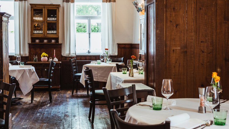 Gemütliches Wirtshaus mit Holzmöbeln und gedeckten Tischen.
