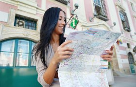 Frau mit Karte vor dem Tourismusbüro St. Pölten.