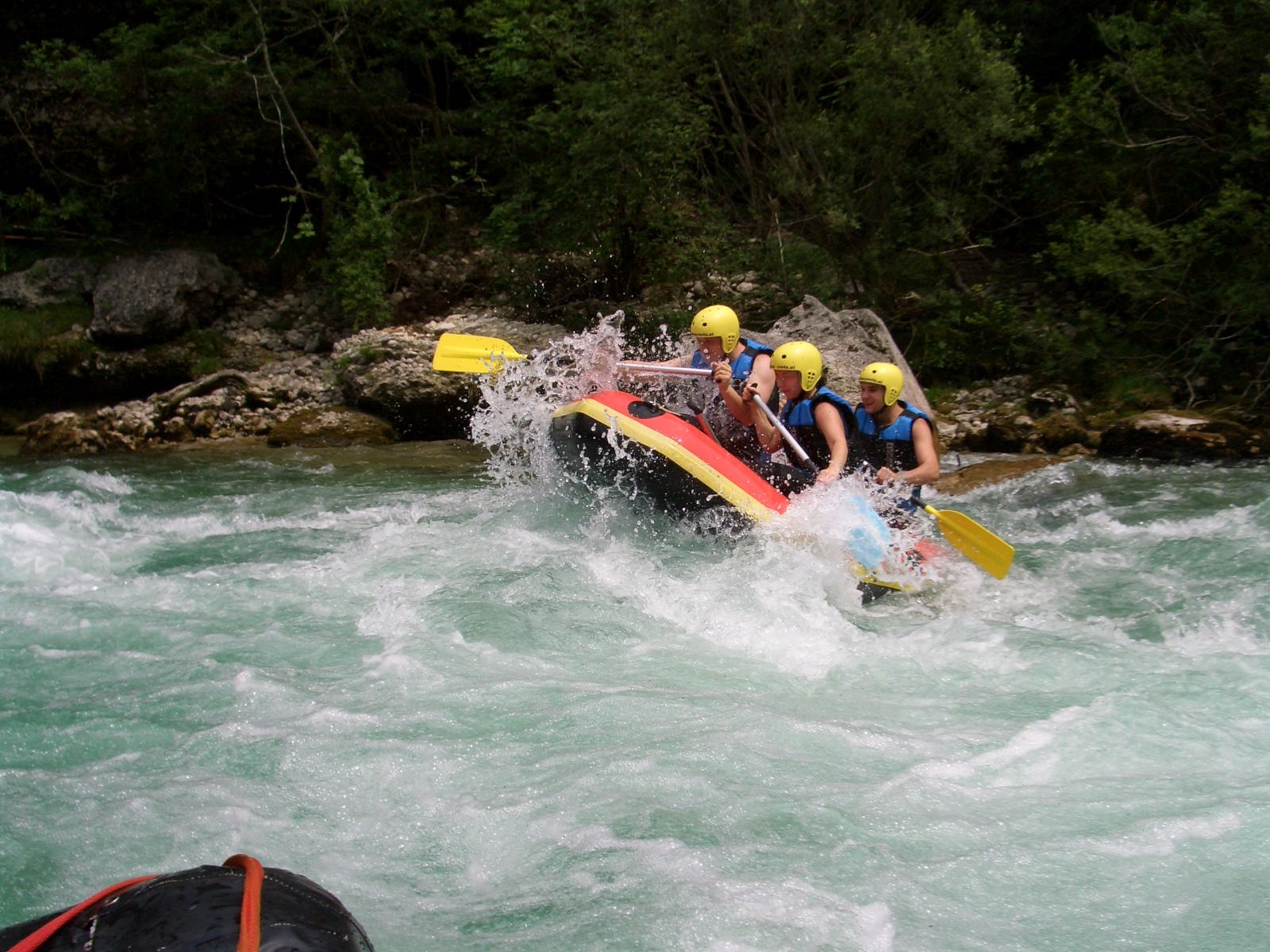 Gruppe von Menschen beim Rafting auf einem wilden Fluss.