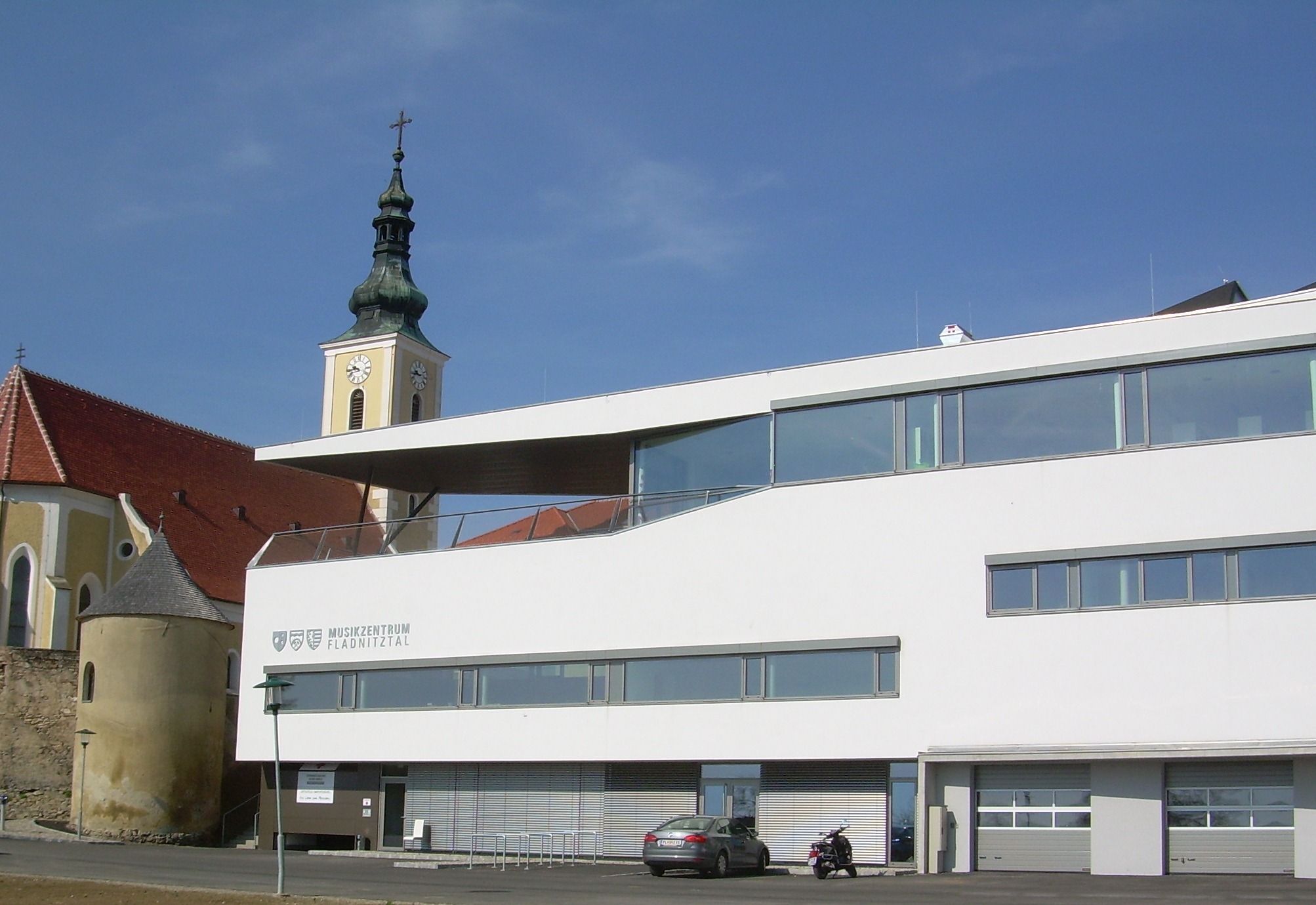 Moderne Gebäude mit Kirchturm im Hintergrund in Wölbling.
