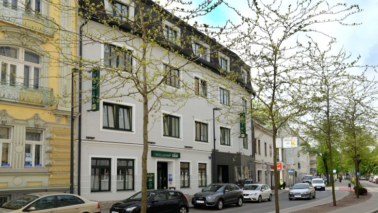 Street view of the Hotel-Gasthof Graf with parked cars and trees.