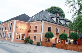 Außenansicht des Landgasthofs Erber mit orangefarbener Fassade und Blumenkästen.