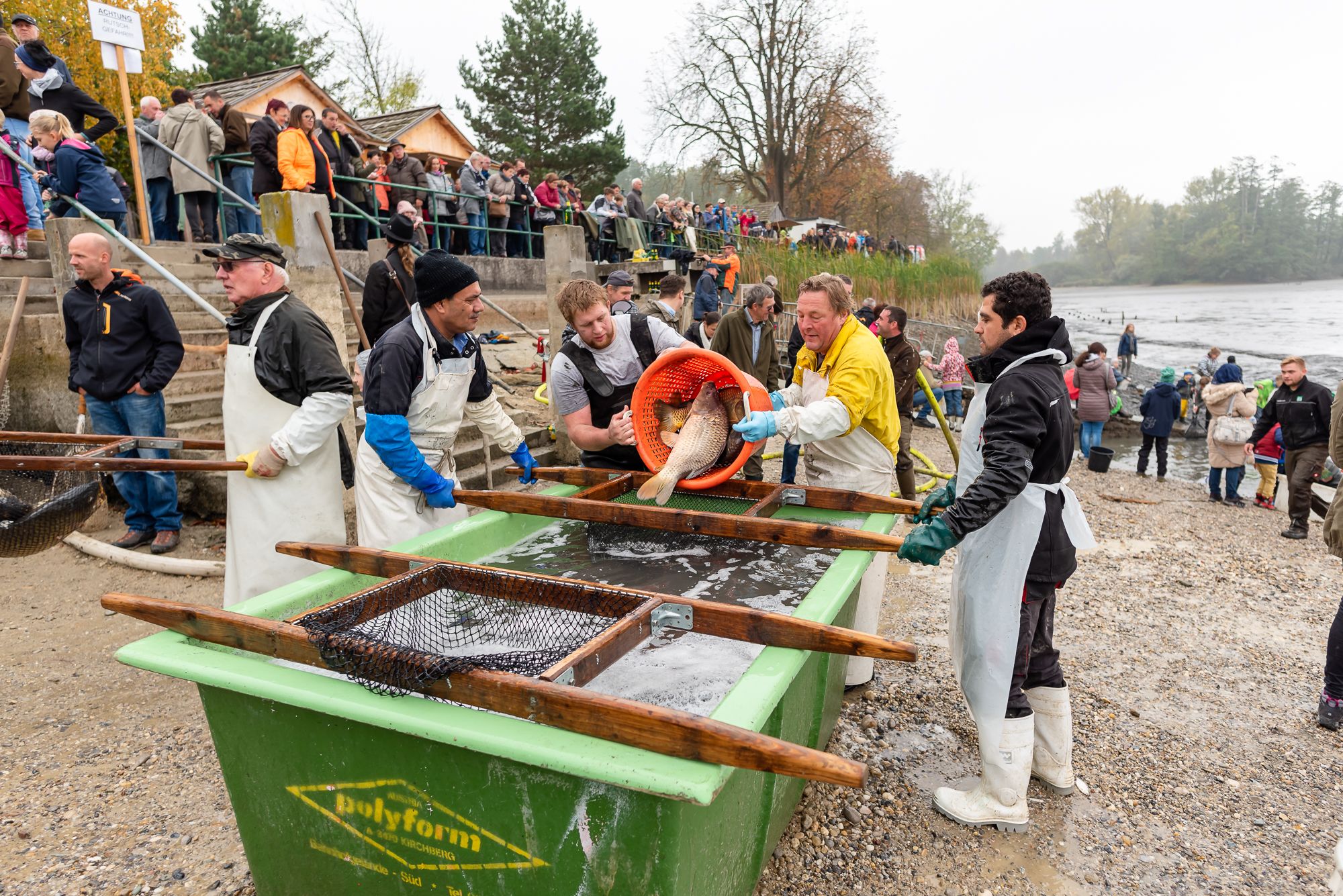 Menschen beim Abfischfest an einem Flussufer.